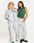 Two women wearing green and white plaid outfits on a white background