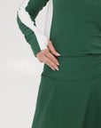 A person wearing a high-waisted green skirt with a solid pattern and ribbed fabric.