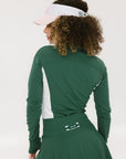 A person wearing a high-waisted green skirt with a solid pattern and ribbed fabric.