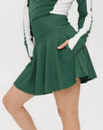 A person wearing a high-waisted green skirt with a solid pattern and ribbed fabric.