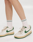 A model wearing pink/white checkered charlie crew socks on a white background.