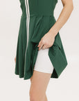 A person wearing white biddy shorties paired under a green Erin dress.