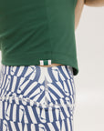 A pair of blue and white geometric shorts, knee-length, worn by a model paired with a green top.