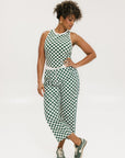 A woman wearing a green checkered tank top with a built-in bra, designed for golfing or casual wear.