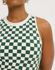 A woman wearing a green checkered tank top with a built-in bra, paired with matching green checkered shorts.