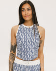 A woman wearing a blue geometric patterned tank top with a built-in bra, paired with matching pants.