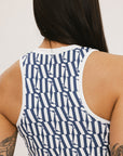 A woman wearing a blue geometric patterned tank top with a built-in bra, paired with matching pants.