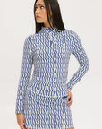A woman wearing a mock neck, long sleeve Bea Base Mock top in an indigo and white pattern.