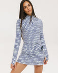 A woman wearing a mock neck, long sleeve Bea Base Mock top in an indigo and white pattern.