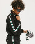 A person wearing a black jacket with green and white stripes on the sleeves