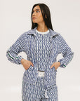 A woman wearing a blue geometric patterned tank top with a built-in bra, paired with matching pants.