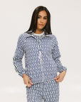 A woman wearing a long sleeve golf jacket with a pattern of blues and whites.