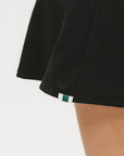 A person wearing a black skirt that reaches mid-thigh.