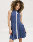 A woman in an indigo sleeveless knee-length dress with a top-to-bottom zipper.