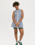 A model wearing a sleeveless blue and white geometric patterned dress with a zipper at the top, suitable for golf.