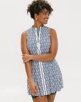 A model wearing a sleeveless blue and white geometric patterned dress with a zipper at the top, suitable for golf.