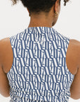 A model wearing a sleeveless blue and white geometric patterned dress with a zipper at the top, suitable for golf.