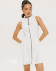 A woman models a white sleeveless dress with a zipper down the front, designed for comfort and movement.