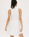 A woman models a white sleeveless dress with a zipper down the front, designed for comfort and movement.