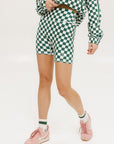 A person wearing green and white checkered biddy shorties and a matching checkered golf jacket, standing against a white background.