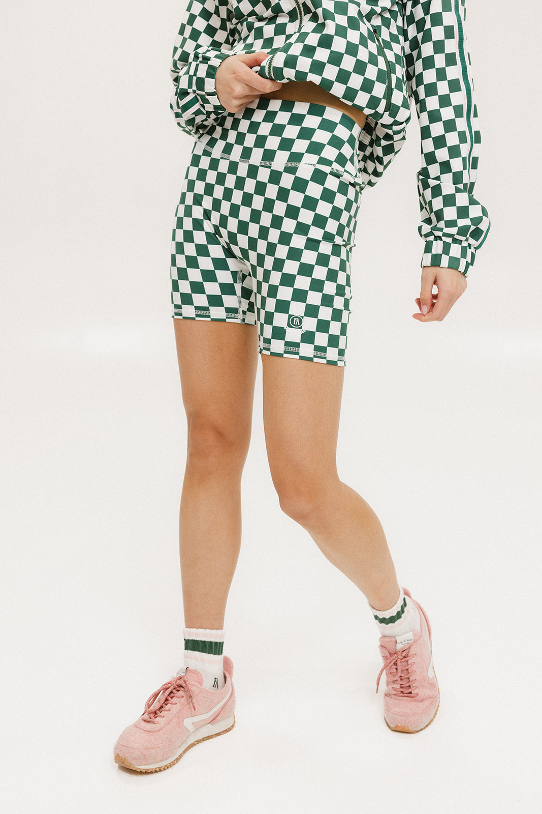 A person wearing green and white checkered biddy shorties and a matching checkered golf jacket, standing against a white background.