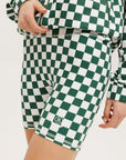 A person wearing green and white checkered biddy shorties and a matching checkered golf jacket, standing against a white background.