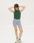 A pair of blue and white geometric shorts, knee-length, worn by a model paired with a green top and white sneakers.