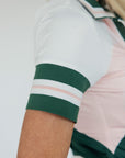 A woman wearing a pink and green Betty Polo shirt with chevron print and a preppy collar.