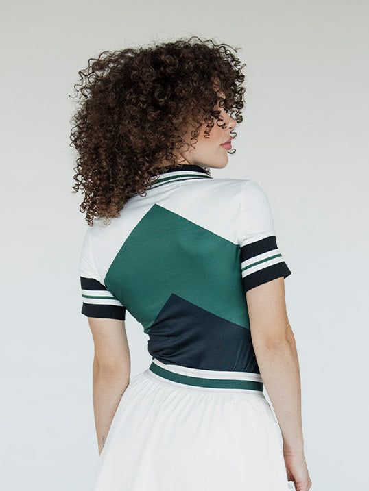 Woman wearing a green and white sports jersey with a plain background