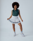 White pleated skirt with blue stripes worn by a person on a plain background