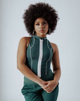 A woman wearing a green checkered full zip tank top with a mock neck.