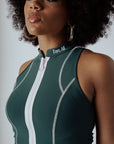 A woman wearing a green checkered full zip tank top with a mock neck.