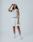 A woman wearing a white ribbed sleeveless golf dress with a high collar and a full front zipper.