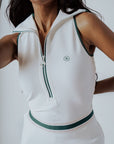 A woman wearing a white ribbed sleeveless golf dress with a high collar and a full front zipper.