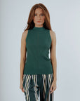 A woman wearing a green sleeveless tank top with a crew neckline and striped pants.