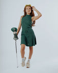 A model wearing a green knee-length skirt with a tie-belt and shorties underneath. The skirt has a textured fabric.