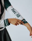 A person wearing a green and pink Micky Quarter Zip golf shirt paired with a green skirt.