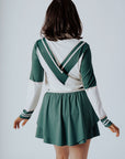A person wearing a green and pink Micky Quarter Zip golf shirt paired with a green skirt.
