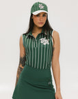 A female model wearing a sleeveless green pinstripe polo top with an applique logo on the chest and a matching green skirt, paired with a green cap.