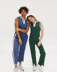 Two women wearing a sleeveless indigo and green polo with a striped collar and v-neck.