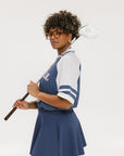A person wearing a blue and white rugby-inspired polo shirt with Mesh body appliqué logos, a ribbed collar and placket, and elastic toggles at the side seam hem. The shirt has 'FORE ALL' text and a golf club logo on the front.