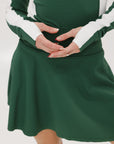 A female model wearing a long sleeve green and white ribbed baselayer top with raglan sleeves and colorblocking.