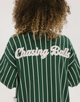 Person wearing a green and white striped cardigan with 'Chasing Balls' text.