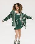 Person wearing a green and white striped cardigan with 'Chasing Balls' text.