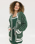 Person wearing a green and white striped cardigan with 'Chasing Balls' text.