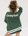 Person wearing a green and white striped cardigan with 'Chasing Balls' text.