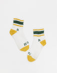 A pair of retro ankle socks with stripes and a logo in mustard and green colors.