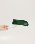 A hand holding a white and green two-toned visor with the word '04' printed on the back.