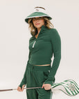 A woman wearing a white and green visor with a 'FA' logo on the front.