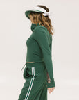 A woman wearing a white and green visor with a 'FA' logo on the front.